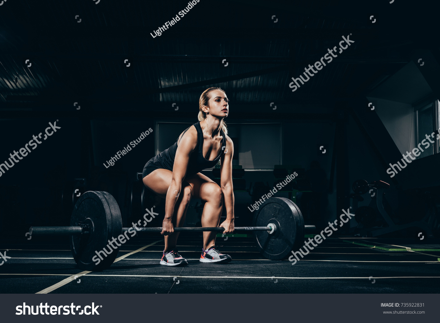 Young Athletic Sportswoman Squatting While Lifting Stock Photo ...