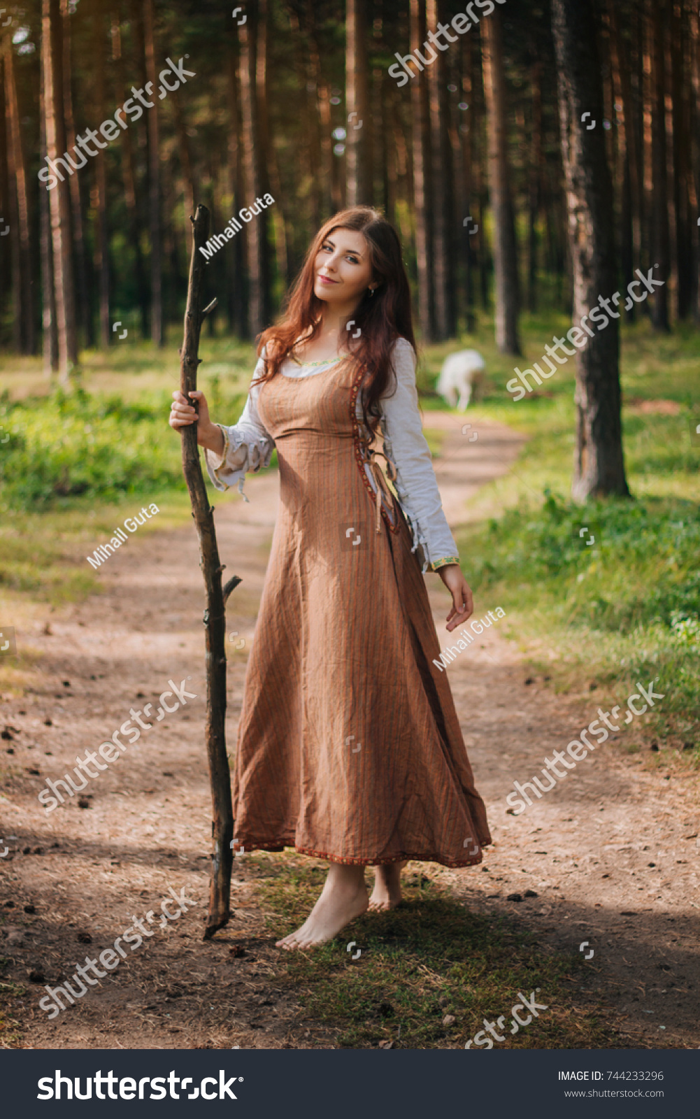https://image.shutterstock.com/z/stock-photo-young-beautiful-girl-in-medieval-cowboy-clothes-with-a-stick-in-hand-barefoot-on-the-ground-744233296.jpg