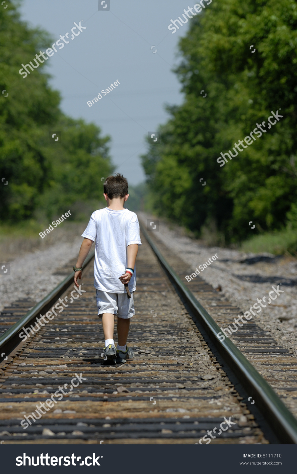 Young Boy Walking Down Railroad Tracks In Summer. Stock Photo 8111710 ...