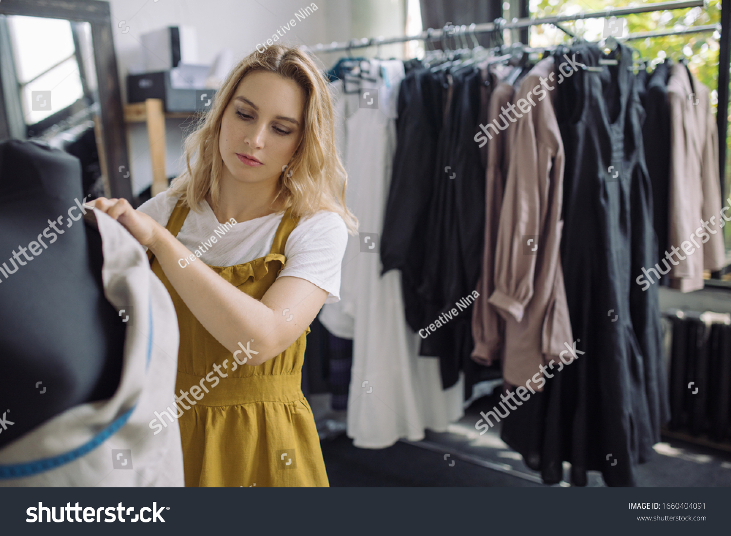 Young Female Dressmaker Adjusting Clothes On Stock Photo (Edit Now