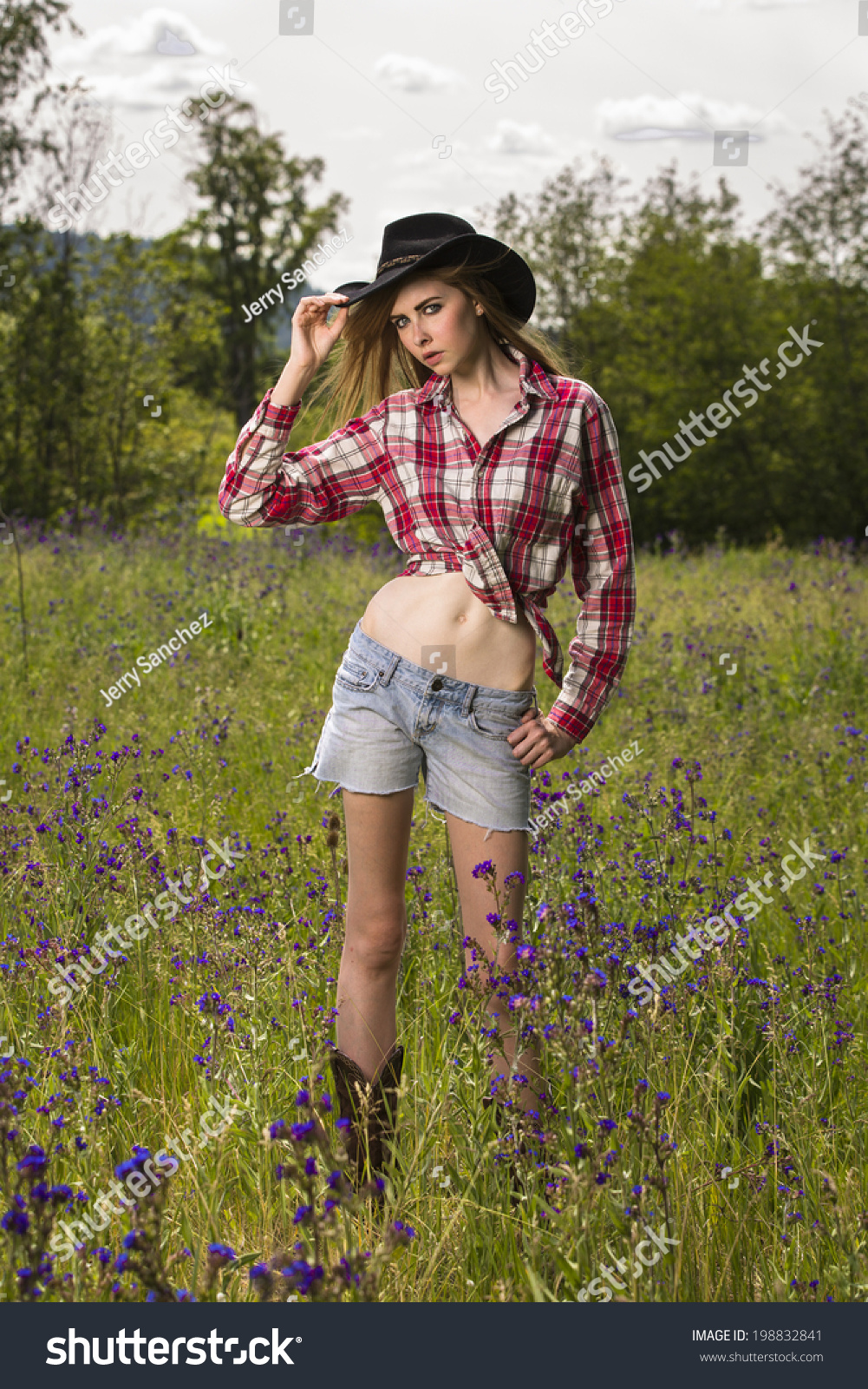 Young Female Model In Tied Up Flannel Shirt And Wearing Cowboy Hat ...