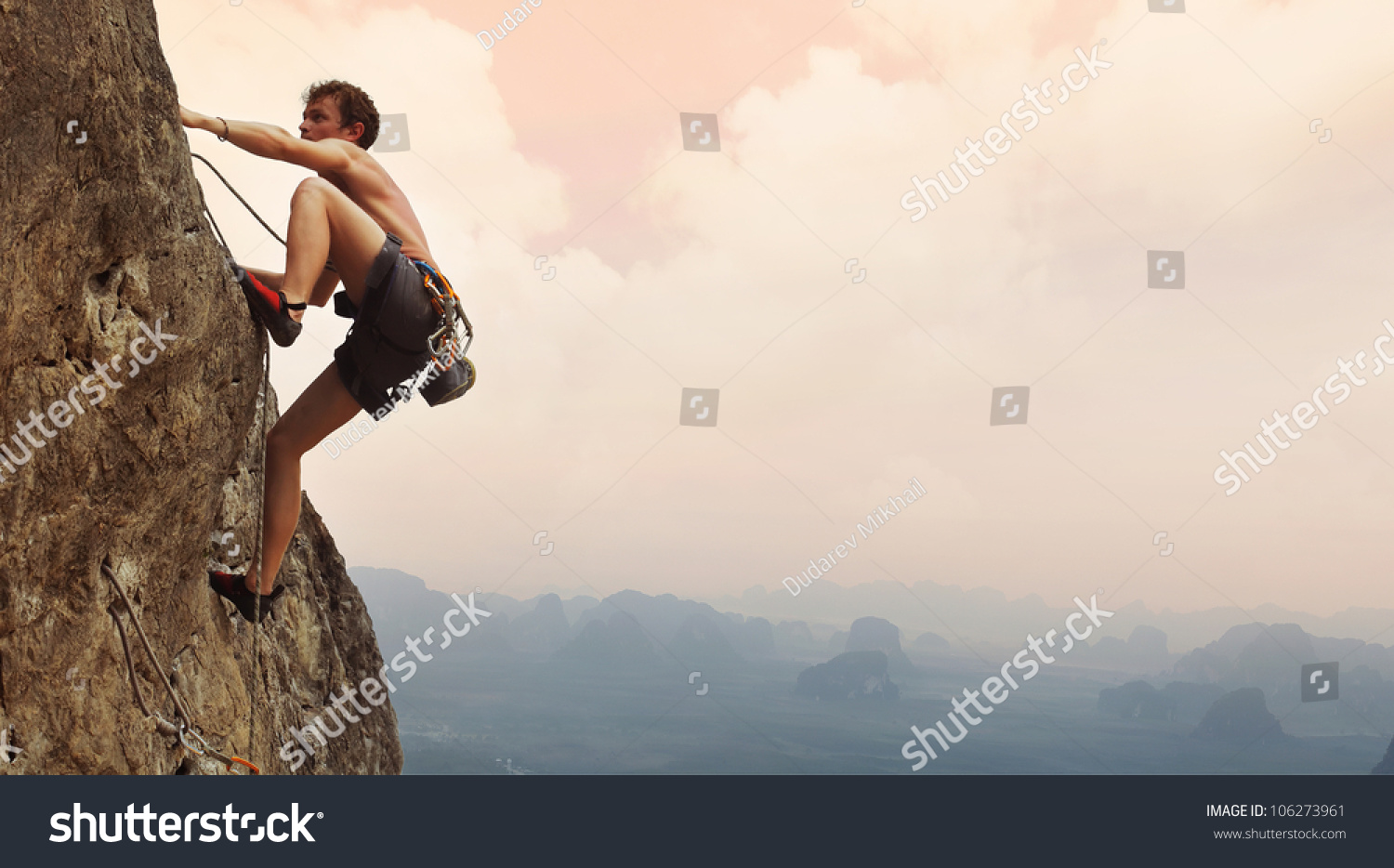 Young Man Climbing On A Limestone Wall With Wide Valley On The ...