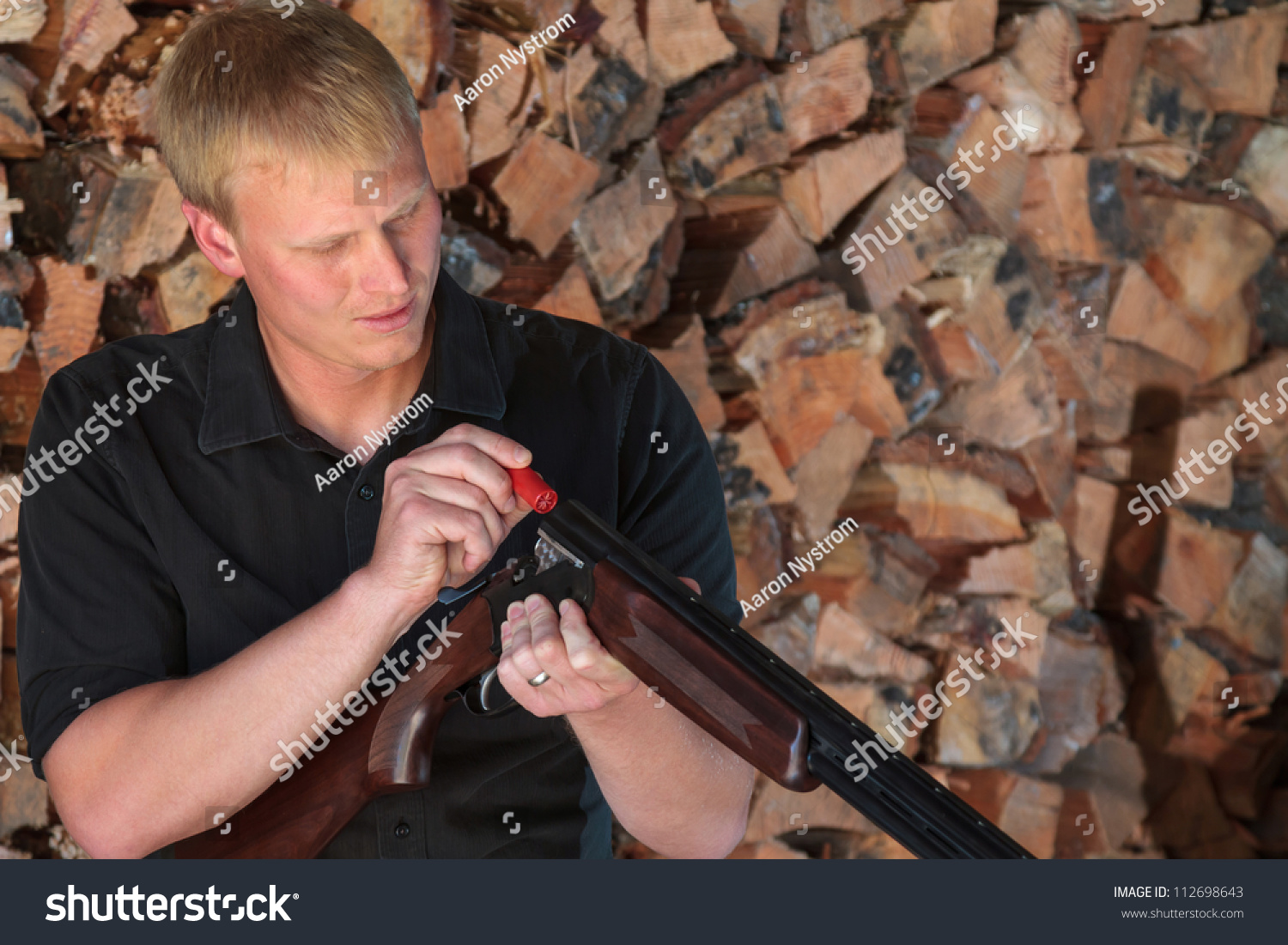 Young Man Loading A Cartridge Into A Double Barrel Shotgun In Front Of ...