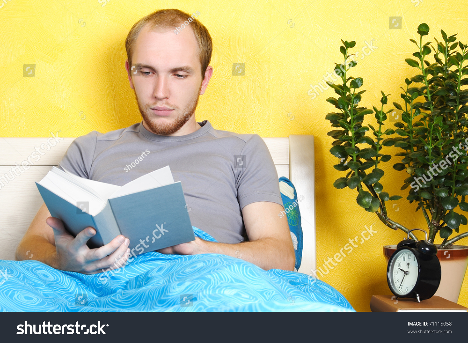 young-man-lying-bed-reading-book-stock-photo-71115058-shutterstock