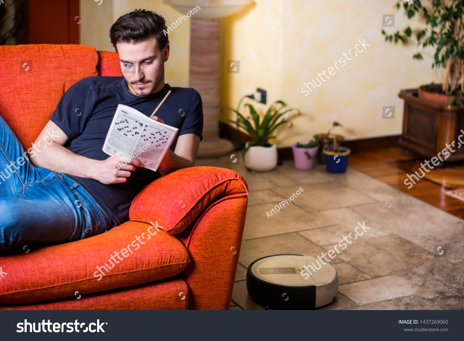 Young Man Sitting Doing Crossword Puzzle Royalty Free Stock Image