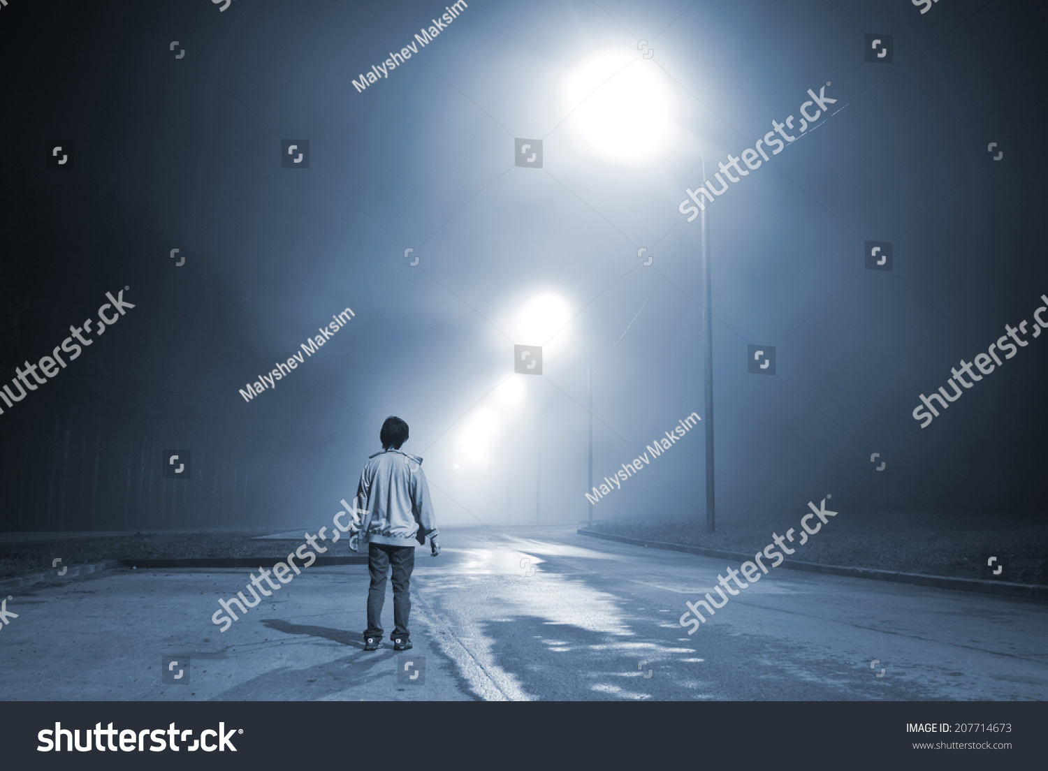 Young Man Standing On The Road In The Fog Near The Forest. Blue Toning ...