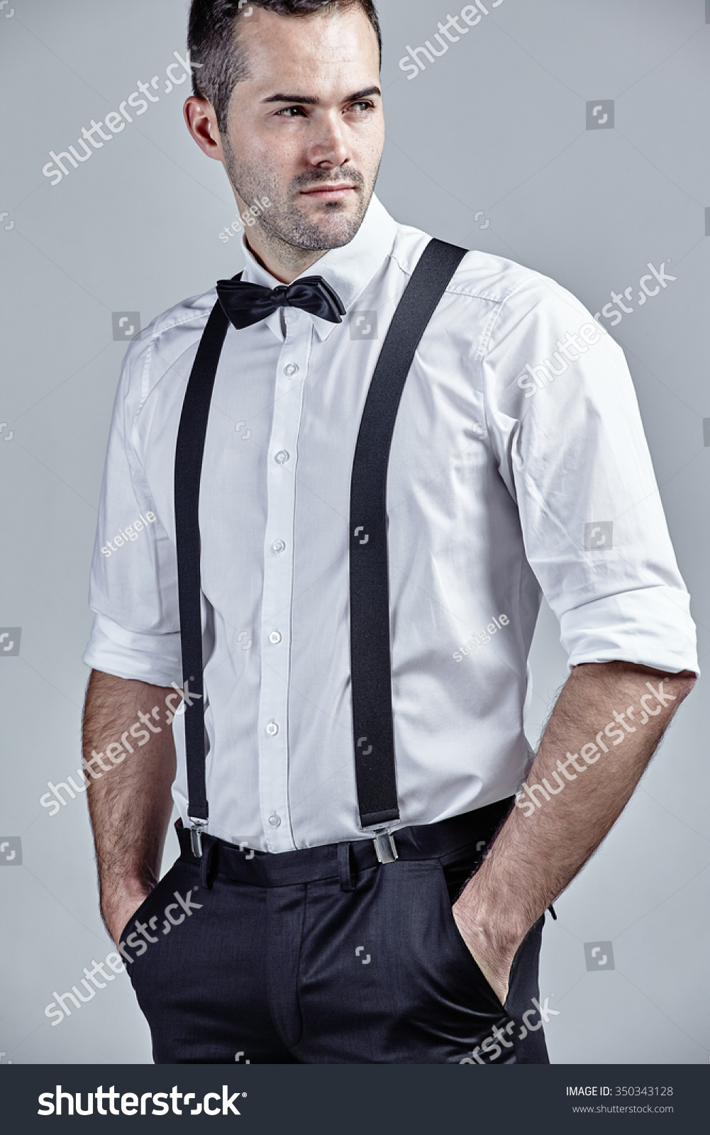 Young Man Wearing Bow Tie And Suspenders Isolated Over Grey Stock Photo ...