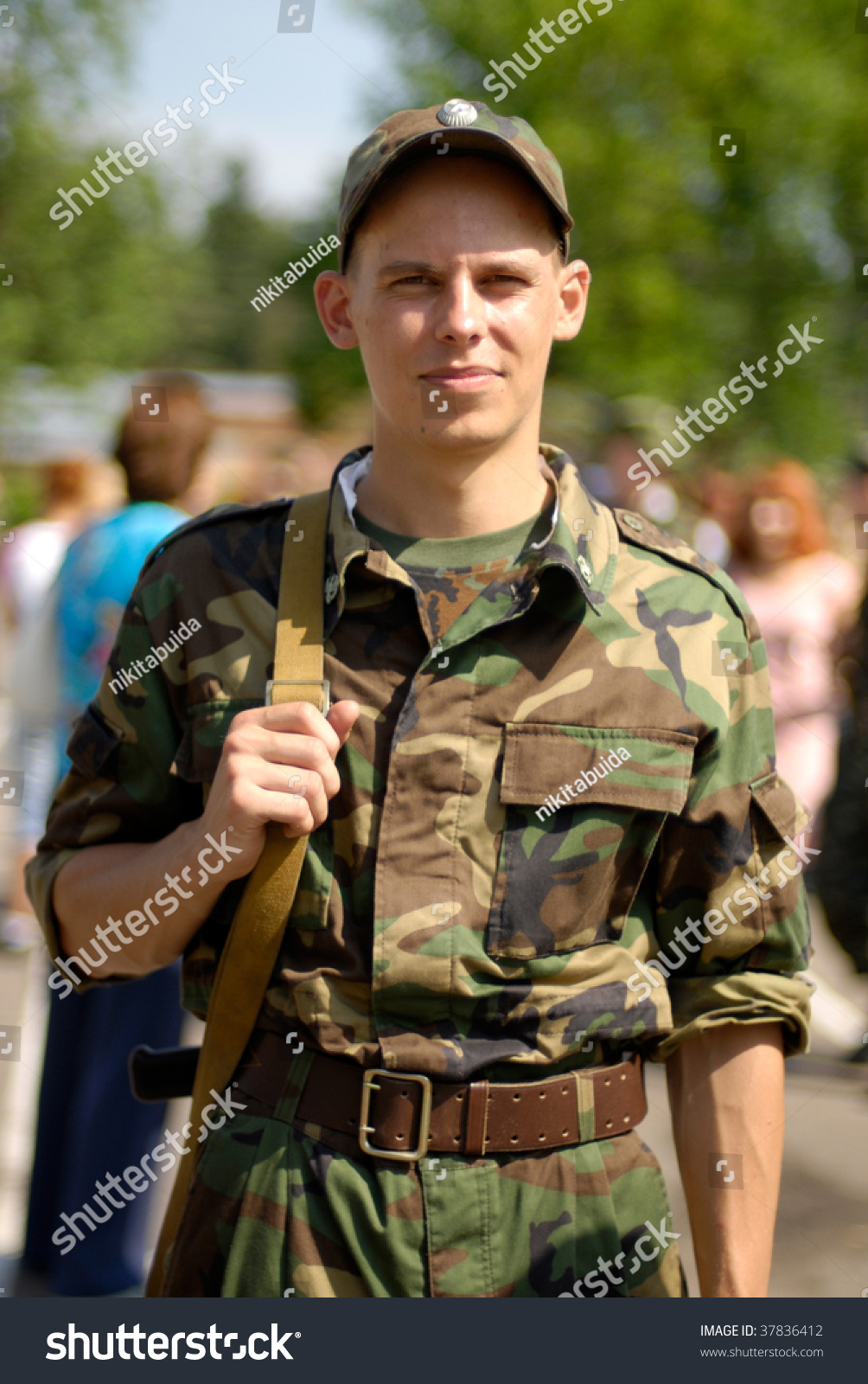 Young Soldier Poses With Some Civilians In The Blurred Out-Of-Focus ...