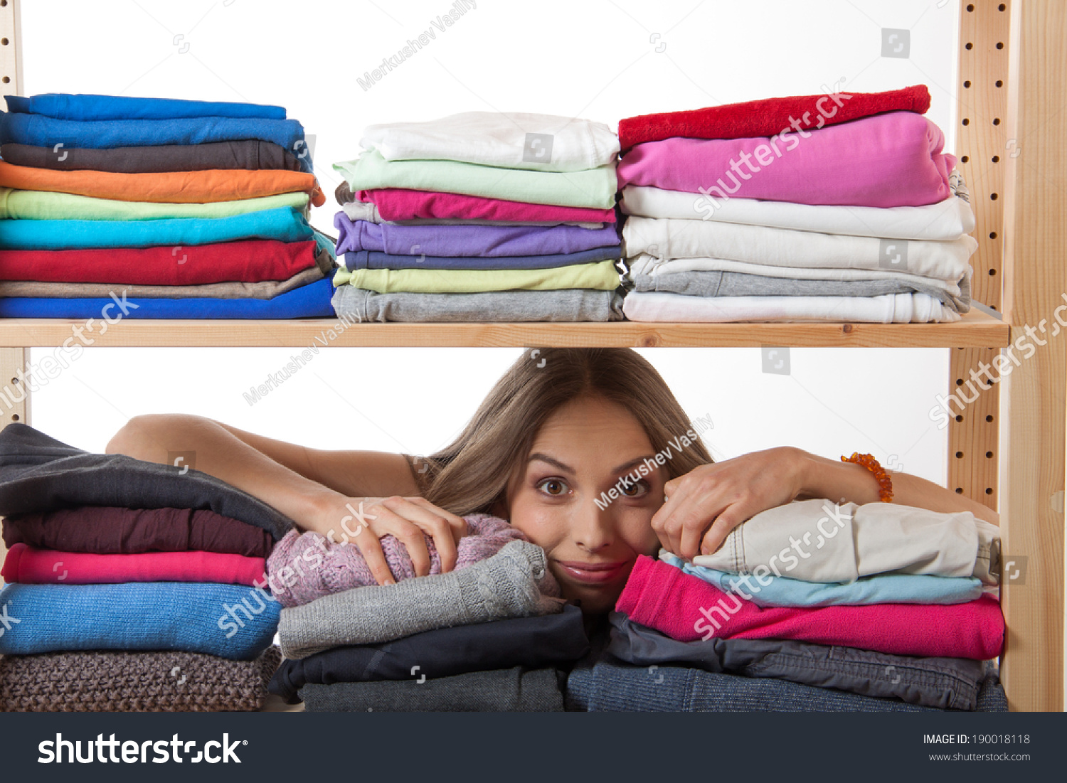 Young Woman Hiding Behind A Shelf With Clothing, Isolated On White ...