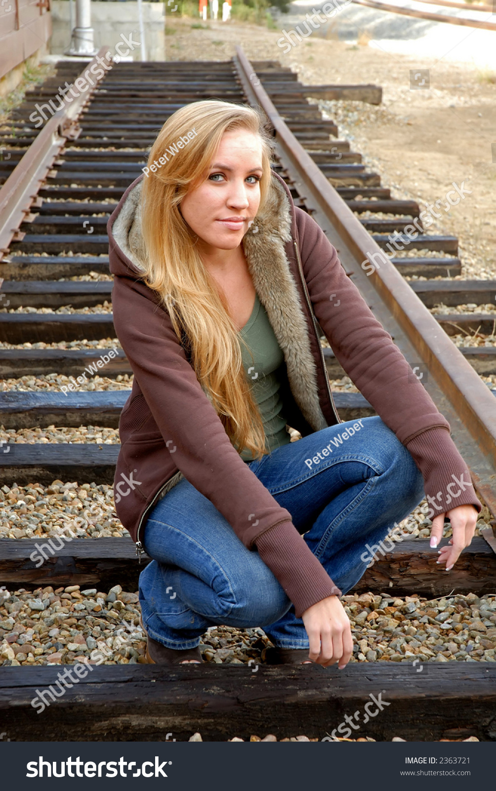 Young Woman Kneeling Between Train Tracks At Railroad Museum Stock ...