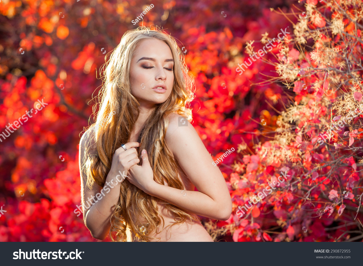 stock-photo-young-woman-on-a-background-of-red-and-yellow-autumn-leaves-with-beautiful-curly-hair-on-his-chest-