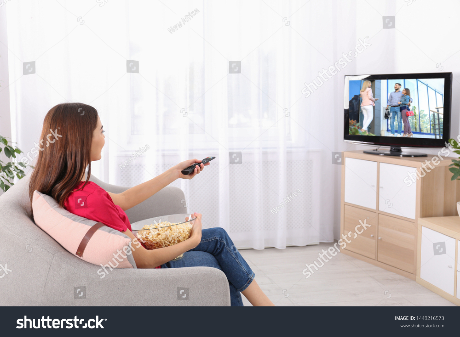 Young Woman Watching Tv On Sofa Stock Photo (Edit Now) 1448216573